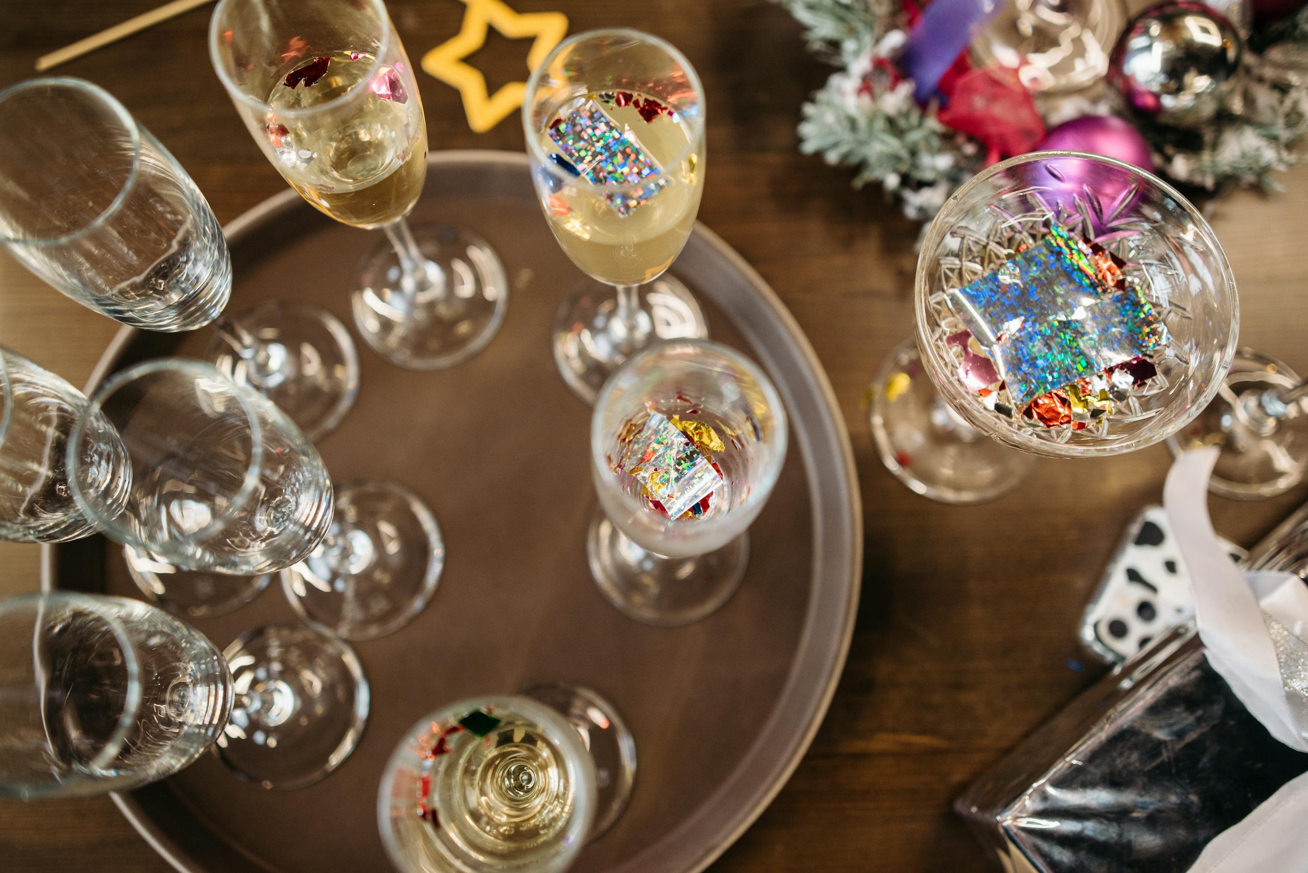 Top view of champagne glasses with colorful decorations, perfect for holiday celebrations.